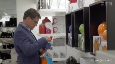 在希腊塞萨洛尼基商店里，戴眼镜的男子正在选购水壶